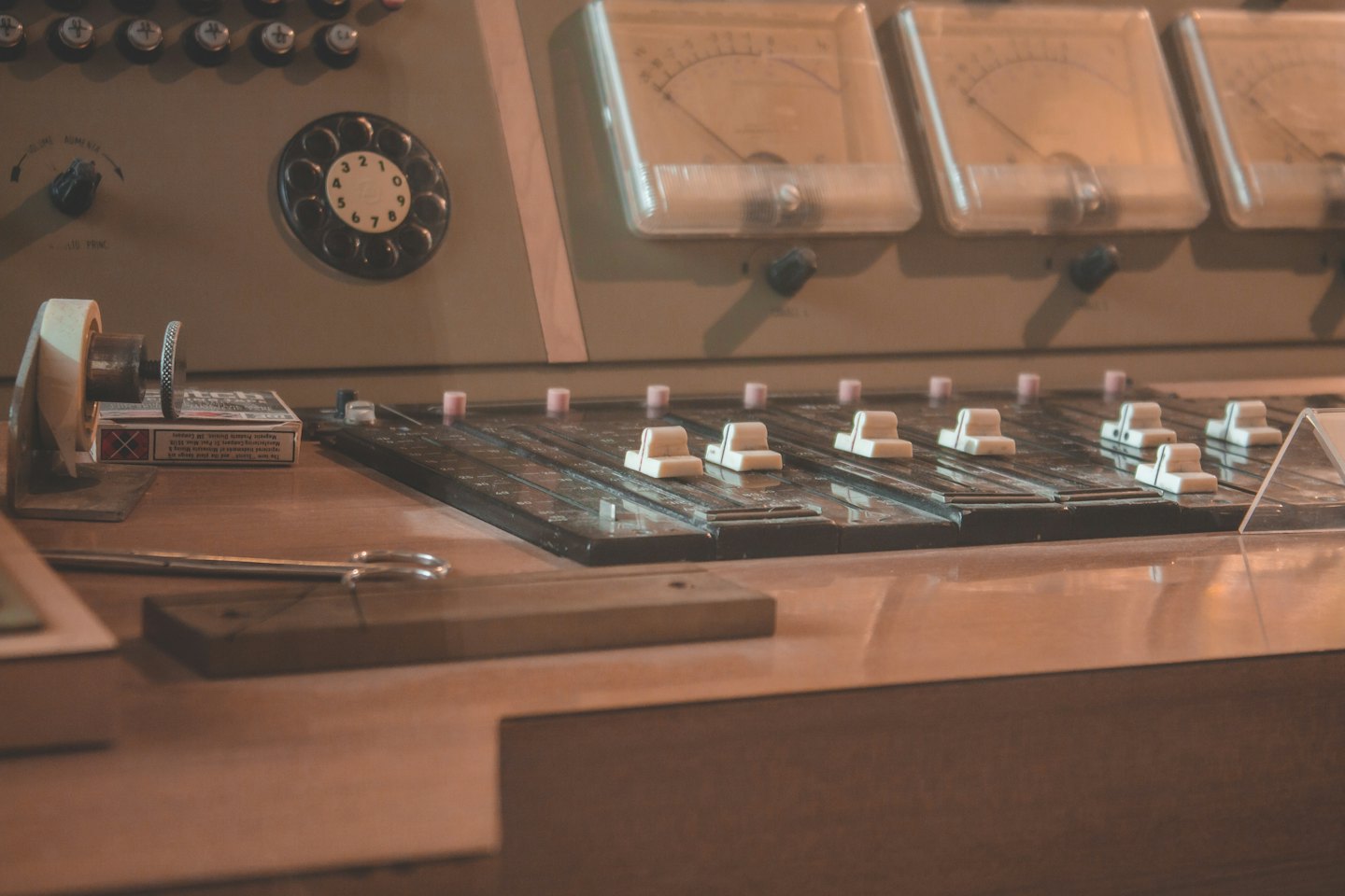 Vintage audio mixing console with analog meters and controls.